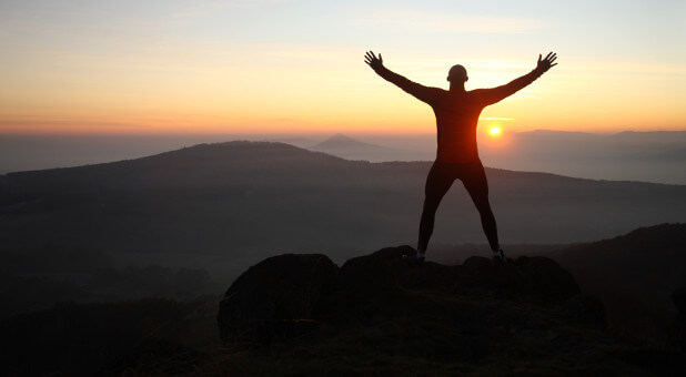 man standing on top of the mountain