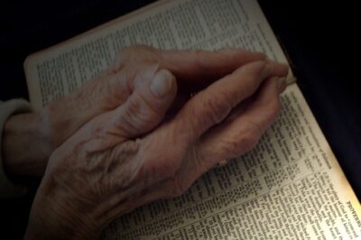 Praying hands on Bible