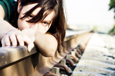woman on railroad track hopeless