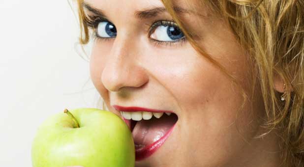 woman eating green apple