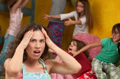stressed out mom with kids jumping up and down