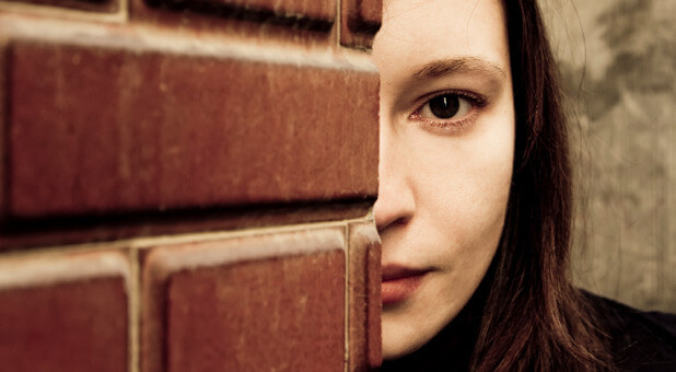 woman hiding behind wall