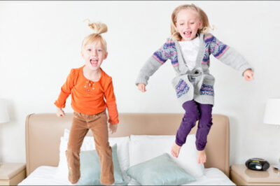 girls jumping on bed