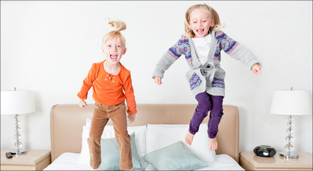 girls jumping on bed