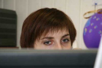 woman looking over cubicle