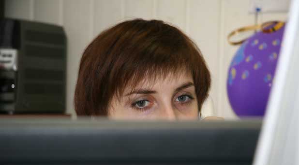 woman looking over cubicle