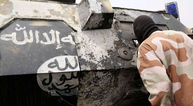 A Chadian soldier peers into a burnt armoured vehicle, which the Chadian military say belonged to insurgent group Boko Haram.