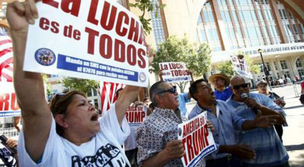 Latinos gather outside Donald Trump's Dallas rally to protest his stance on immigration.