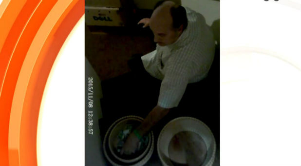 A man appears to be taking money right out of the offering plate.