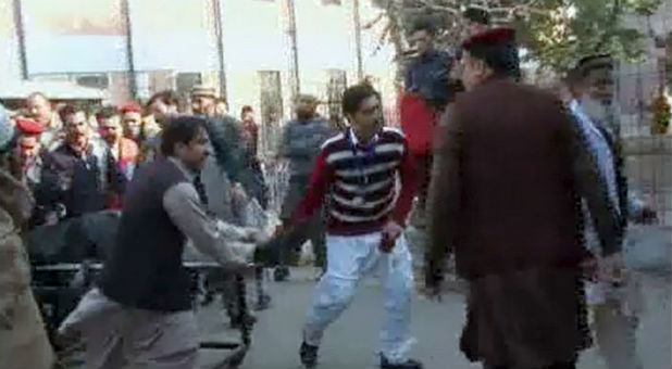 People carry a victim from the terrorist attack in Pakistan.