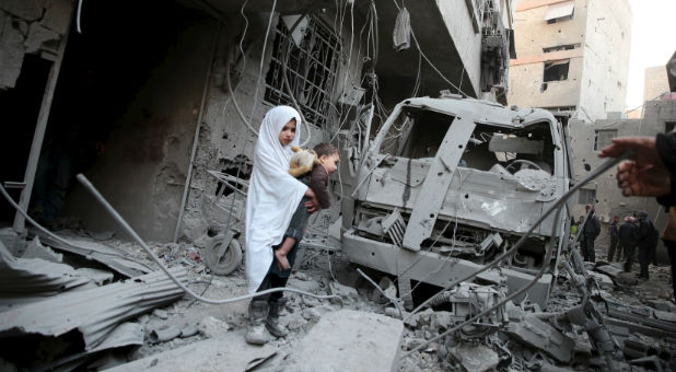 A little Syrian girl holds her doll after an airstrike.