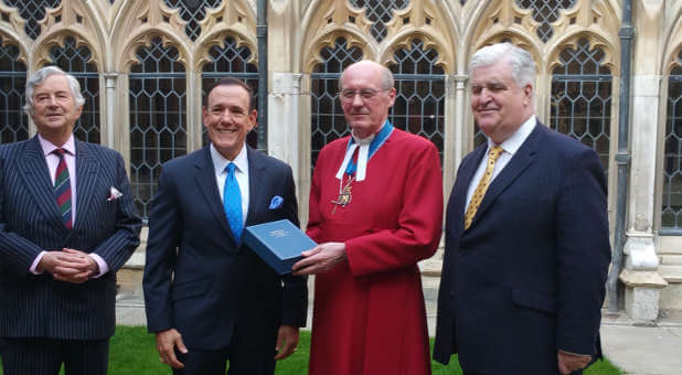 The Dean of Windsor David Conner accepts the special Bible for Queen Elizabeth II from Charisma Media CEO Steve Strang, miiddle left, at Windsor Castle in England on May 8. At left is British Col. David Waddell (Ret.) and on the far right is English businessman Martin Clarke.