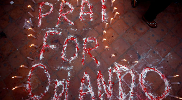 Candles are lit around a sign that reads
