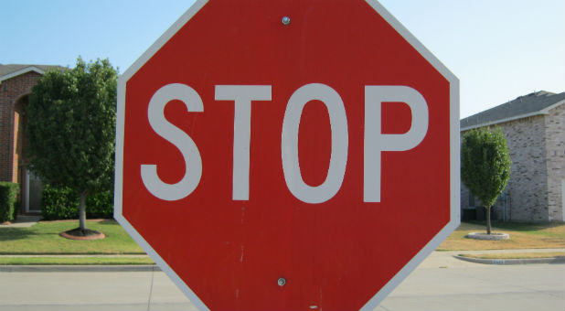 A woman ran a stop sign and crashed into a house because she was praying with her eyes closed.