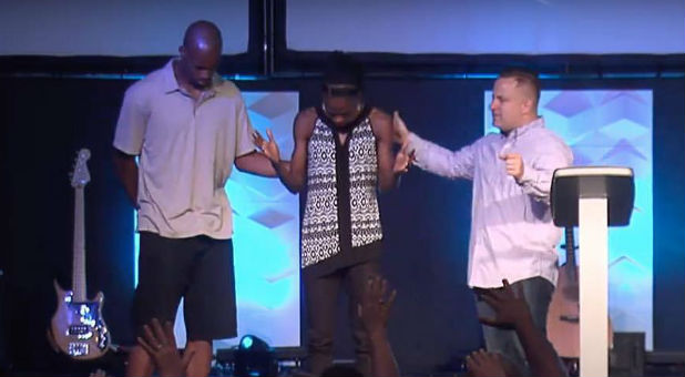 Mario Lowe, Chaunte Lowe and Pastor Kevin Quinones pray at River of Life Church in Oviedo, Florida, before Chaunte's Olympic Qualifiers.
