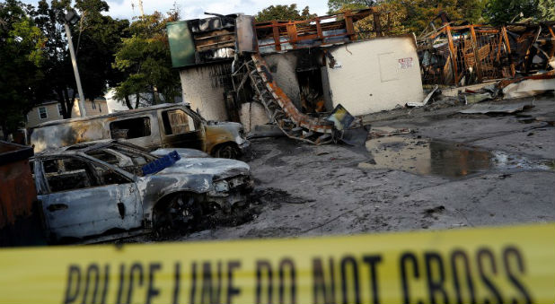 A gas station is seen burned down after disturbances following the police shooting of a man in Milwaukee, Wisconsin