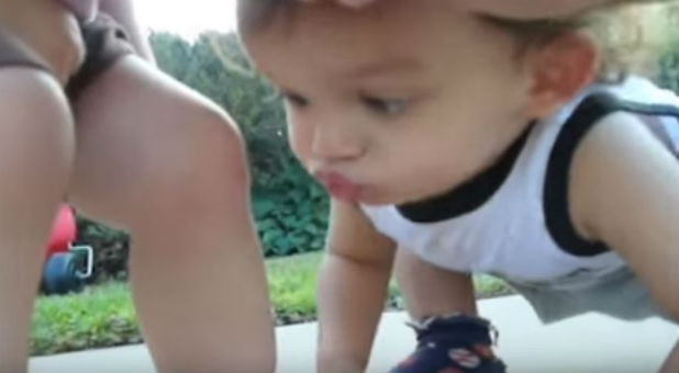 A little boy kisses a boo boo.