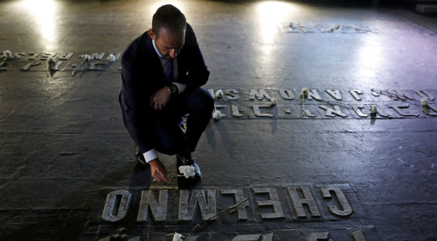 A visitor places a flower next to the name of a former concentration camp as he visits the Hall of Remembrance at Yad Vashem Holocaust Memorial during Holocaust Remembrance Day.