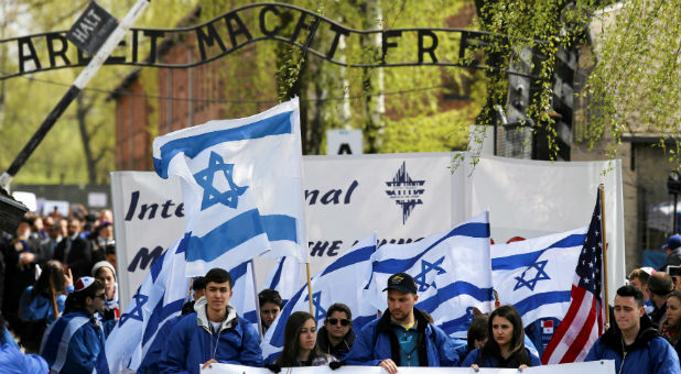 People walk in front of a gate with the words