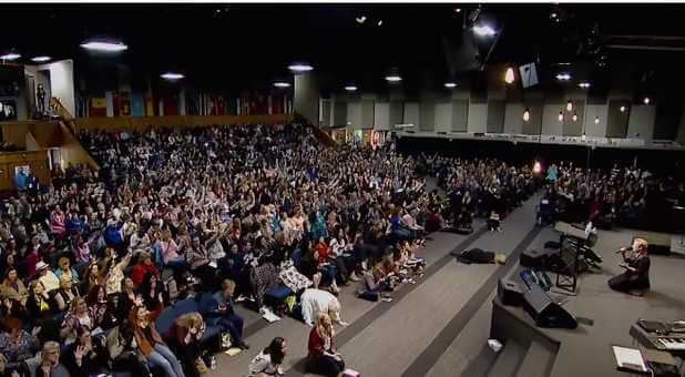 Heidi Baker opens her session on her knees crying out to God at the Unwavering: Anchored in Christ women's gathering in Kansas City.