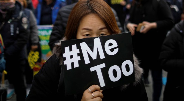 People attend a protest as a part of the #MeToo movement.