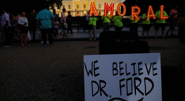 #KremlinAnnex protesters place a sign referring to Christine Blasey Ford, the woman who accused Supreme Court nominee Judge Brett Kavanaugh of a 1982 sexual assault, and spell out the word