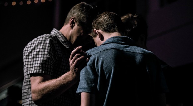 Two men pray for each other.