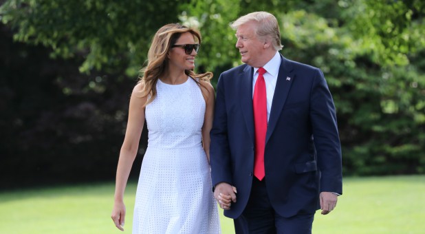 U.S. President Donald Trump walks with first lady Melania Trump as they depart the White House on travel to Orlando, Florida from the White House.