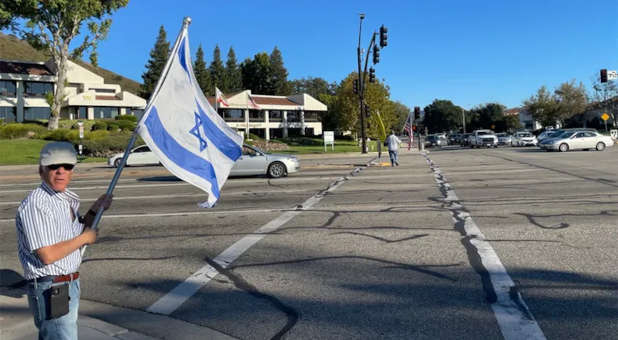 Paul Kessler holding Israeli flag.