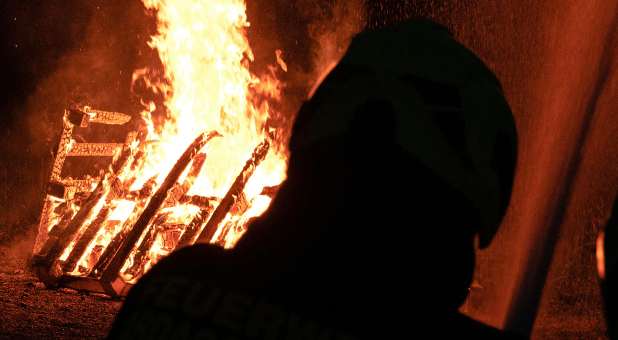 shadowed figure with flames in background